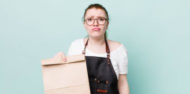 Kızıl saçlı, güzel bir kadın üzgün ve mızmızlanıyor. Mutsuz bir bakışı var ve ağlıyor. teslimat kavramını kaldır