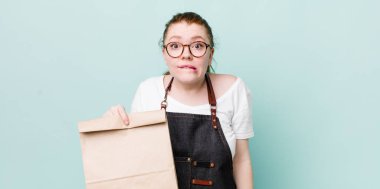 Kızıl saçlı güzel kadın kafası karışık ve şaşkın görünüyor. teslimat kavramını kaldır