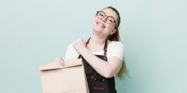 Kızıl saçlı güzel bir kadın kendini mutlu hissediyor ve bir meydan okumayla yüzleşiyor ya da kutluyor. teslimat kavramını kaldır