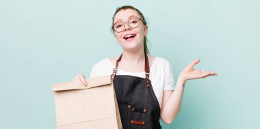 Kızıl saçlı güzel kadın kendini mutlu hissediyor, bir çözüm ya da fikir bulduğuna şaşırıyor. teslimat kavramını kaldır