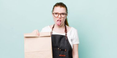 Kızıl saçlı güzel kadın iğrenmiş ve sinirlenmiş hissediyor ve dilini dışarı çıkarıyor. teslimat kavramını kaldır