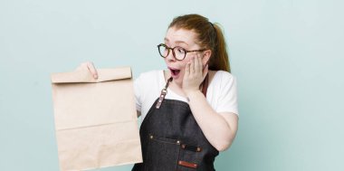 Kızıl saçlı güzel kadın mutlu, heyecanlı ve şaşırmış hissediyor. teslimat kavramını kaldır