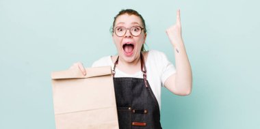 Kızıl saçlı, güzel bir kadın bir fikri fark ettikten sonra mutlu ve heyecanlı bir dahi gibi hissediyor. teslimat kavramını kaldır