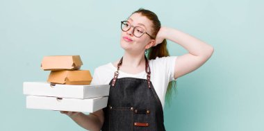 Kızıl saçlı güzel kadın şaşkın ve kafası karışık, kaşınan bir kafa hissediyor. teslimat kavramını kaldır