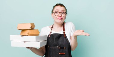 Kızıl saçlı güzel kadın şaşkın, şaşkın ve şüpheci hissediyor. teslimat kavramını kaldır