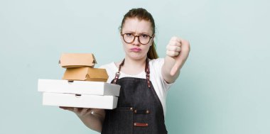 Kızıl saçlı, güzel bir kadın kendini kötü hissediyor, baş parmağını kaldırıyor. teslimat kavramını kaldır