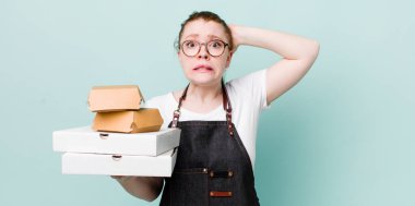 Kızıl saçlı güzel kadın stresli, endişeli ya da korkmuş, elleri başının üstünde. teslimat kavramını kaldır