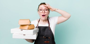 Kızıl saçlı güzel kadın mutlu, şaşkın ve şaşırmış görünüyor. teslimat kavramını kaldır