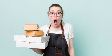 Kızıl saçlı güzel kadın çok şaşırmış ya da şaşkın görünüyor. teslimat kavramını kaldır