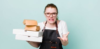 Kızıl saçlı, güzel bir kadın sinirli, sinirli ve sinirli görünüyor. teslimat kavramını kaldır