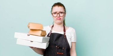 Kızıl saçlı, güzel bir kadın üzgün ve mızmızlanıyor. Mutsuz bir bakışı var ve ağlıyor. teslimat kavramını kaldır