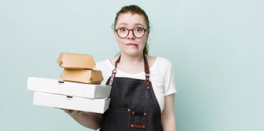 Kızıl saçlı güzel kadın kafası karışık ve şaşkın görünüyor. teslimat kavramını kaldır