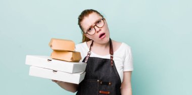 Kızıl saçlı güzel kadın şaşkın ve şaşkın hissediyor. teslimat kavramını kaldır