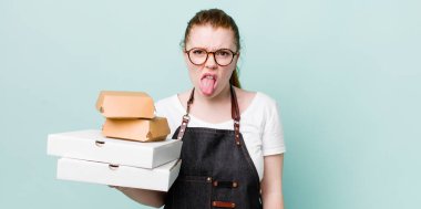 Kızıl saçlı güzel kadın iğrenmiş ve sinirlenmiş hissediyor ve dilini dışarı çıkarıyor. teslimat kavramını kaldır