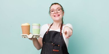 Kızıl saçlı güzel kadın kamerayı işaret ederek seni seçiyor. kahve konseptini kaldır.