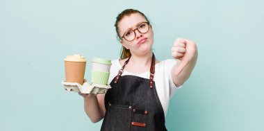 Kızıl saçlı, güzel bir kadın kendini kötü hissediyor, baş parmağını kaldırıyor. kahve konseptini kaldır.