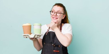 Kızıl saçlı, güzel bir kadın mutlu, kendinden emin, elleri çenesinde gülümsüyor. kahve konseptini kaldır.