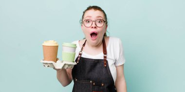 Kızıl saçlı güzel kadın çok şaşırmış ya da şaşkın görünüyor. kahve konseptini kaldır.