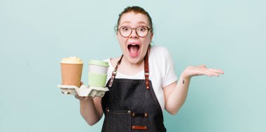 Kızıl saçlı güzel kadın kendini mutlu hissediyor ve inanılmaz bir şeye hayret ediyor. kahve konseptini kaldır.