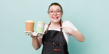 Kızıl saçlı güzel bir kadın mutlu hissediyor ve heyecanla kendini işaret ediyor. kahve konseptini kaldır.