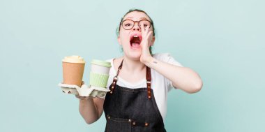 Kızıl saçlı, güzel bir kadın kendini mutlu hissediyordu. Elleri ağzının kenarında bağırıyordu. kahve konseptini kaldır.