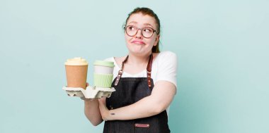 Kızıl saçlı güzel kadın omuz silkiyor, kafası karışık ve kararsız. kahve konseptini kaldır.