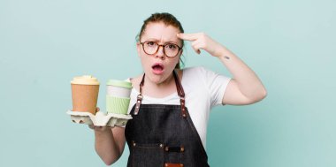 Kızıl saçlı güzel kadın kafası karışık ve şaşkın hissediyor, deli olduğunu gösteriyor. kahve konseptini kaldır.