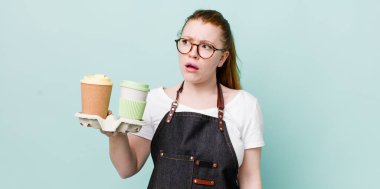 Kızıl saçlı, güzel bir kadın üzgün, üzgün ya da kızgın ve yana bakıyor. kahve konseptini kaldır.