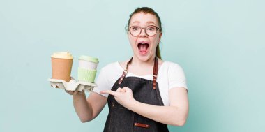 Kızıl saçlı, güzel bir kadın heyecanlı ve şaşırmış görünüyor. kahve konseptini kaldır.