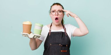 Kızıl saçlı güzel kadın şaşırmış görünüyor, yeni bir düşünce, fikir ya da konsept fark ediyor. kahve konseptini kaldır.