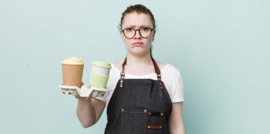 Kızıl saçlı, güzel bir kadın üzgün ve mızmızlanıyor. Mutsuz bir bakışı var ve ağlıyor. kahve konseptini kaldır.