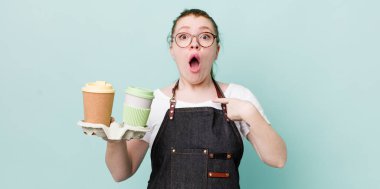 Kızıl saçlı güzel kadın şok olmuş ve ağzı açık, kendini işaret eden bir şekilde şaşırmış görünüyor. kahve konseptini kaldır.