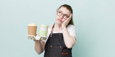 Kızıl saçlı, güzel bir kadın bıkkın, yorgun ve uykulu hissediyor. kahve konseptini kaldır.