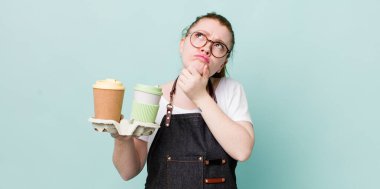 Kızıl saçlı güzel kadın düşünüyor, kuşkulu ve şaşkın hissediyor. kahve konseptini kaldır.