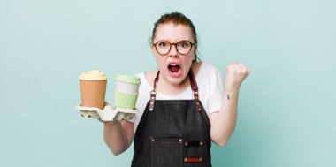 Kızıl saçlı güzel bir kadın sinirli bir ifadeyle agresif bir şekilde bağırıyor. kahve konseptini kaldır.