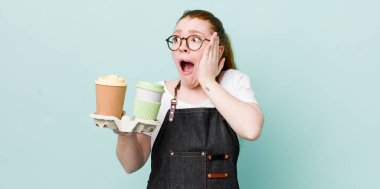 Kızıl saçlı güzel kadın mutlu, heyecanlı ve şaşırmış hissediyor. kahve konseptini kaldır.