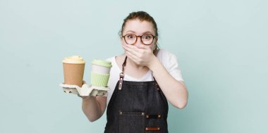 Kızıl saçlı, güzel bir kadın elleri ile ağzını kapatıyor. kahve konseptini kaldır.