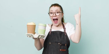 Kızıl saçlı, güzel bir kadın bir fikri fark ettikten sonra mutlu ve heyecanlı bir dahi gibi hissediyor. kahve konseptini kaldır.