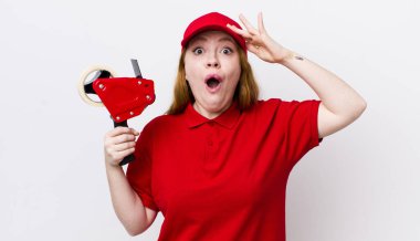 Kızıl saçlı güzel kadın mutlu, şaşkın ve şaşırmış görünüyor. Packer çalışanı konsepti