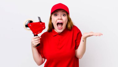 Kızıl saçlı güzel kadın kendini mutlu hissediyor ve inanılmaz bir şeye hayret ediyor. Packer çalışanı konsepti