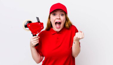 Kızıl saçlı güzel kadın şok olmuş hissediyor, gülüyor ve başarıyı kutluyor. Packer çalışanı konsepti