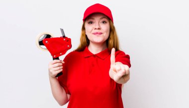 Kızıl saçlı güzel kadın gururla gülümsüyor ve kendinden emin bir numara oluyor. Packer çalışanı konsepti