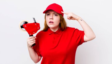 Kızıl saçlı güzel kadın kafası karışık ve şaşkın hissediyor, deli olduğunu gösteriyor. Packer çalışanı konsepti