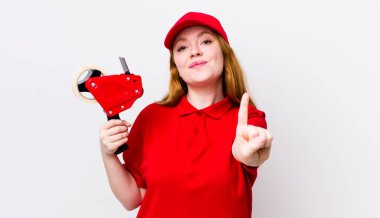 Kızıl saçlı güzel kadın gülümsüyor ve arkadaş canlısı görünüyor, bir numarayı gösteriyor. Packer çalışanı konsepti