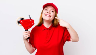 Kızıl saçlı, güzel bir kadın kendi gülüşünü işaret ediyor. Packer çalışanı konsepti