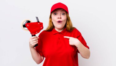 Kızıl saçlı güzel kadın şok olmuş ve ağzı açık, kendini işaret eden bir şekilde şaşırmış görünüyor. Packer çalışanı konsepti