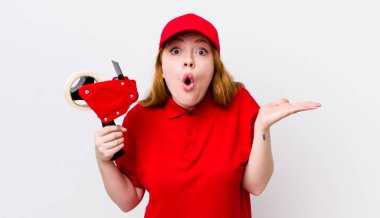 Kızıl saçlı, güzel bir kadın şaşırmış ve şok olmuş görünüyor. Çenesi düşmüş, elinde bir nesne var. Packer çalışanı konsepti