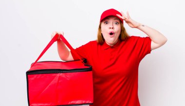 Kızıl saçlı güzel kadın mutlu, şaşkın ve şaşırmış görünüyor. Pizza teslimatı kavramı