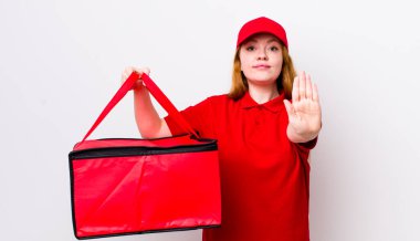 Kızıl saçlı güzel kadın ciddi görünüyor. Avuç içini gösteriyor. Durdurma hareketi yapıyor. Pizza teslimatı kavramı