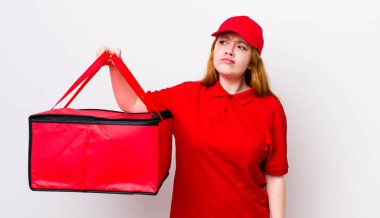 Kızıl saçlı, güzel bir kadın üzgün, üzgün ya da kızgın ve yana bakıyor. Pizza teslimatı kavramı